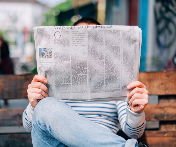 Persona leyendo un periódico.