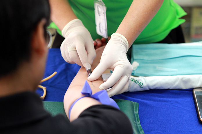 Enfermera extrayendo sangre a un paciente 