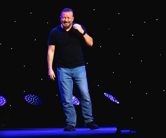 Ricky Gervais en un escenario con baja iluminación