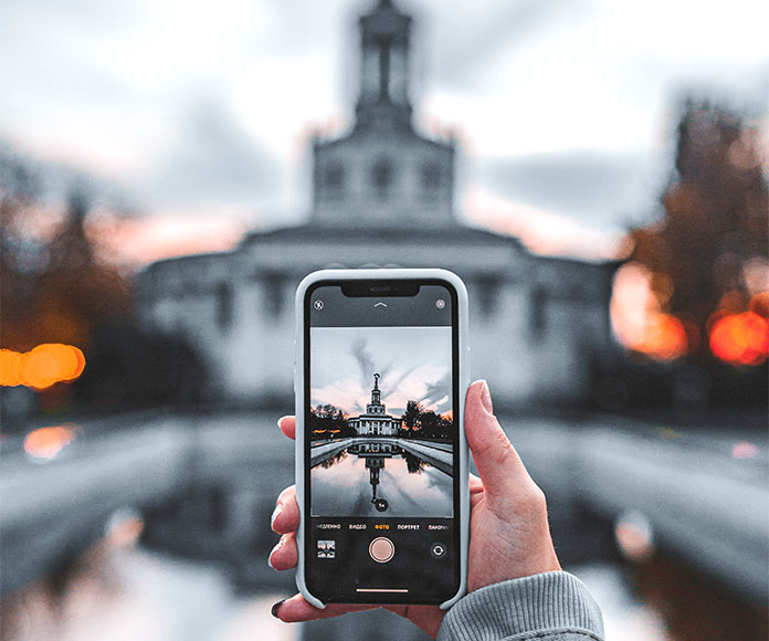 Persona sacando una foto de un edificio con el teléfono móvil