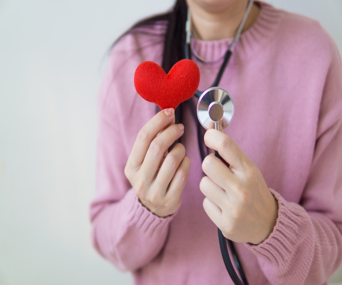 Mujer sosteniendo corazón y estetoscopio