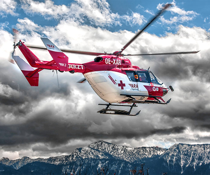 Helicóptero de rescate volando sobre una cordillera montañosa
