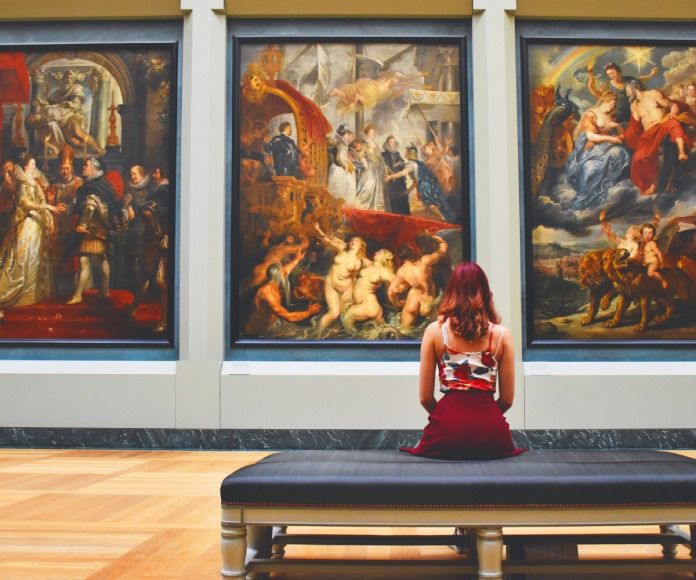 Mujer apreciando cuadros en un museo o galería.