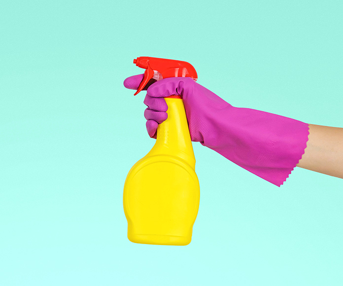 brazo de una persona sujetando un spray de limpieza