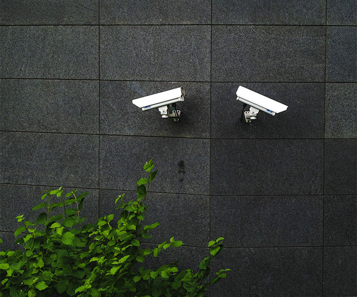 Dos cámaras de seguridad en una esquina de un edificio negro