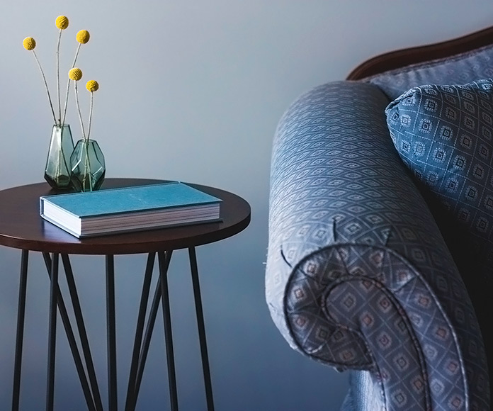 sofá tapizado junto a una mesa con un libro
