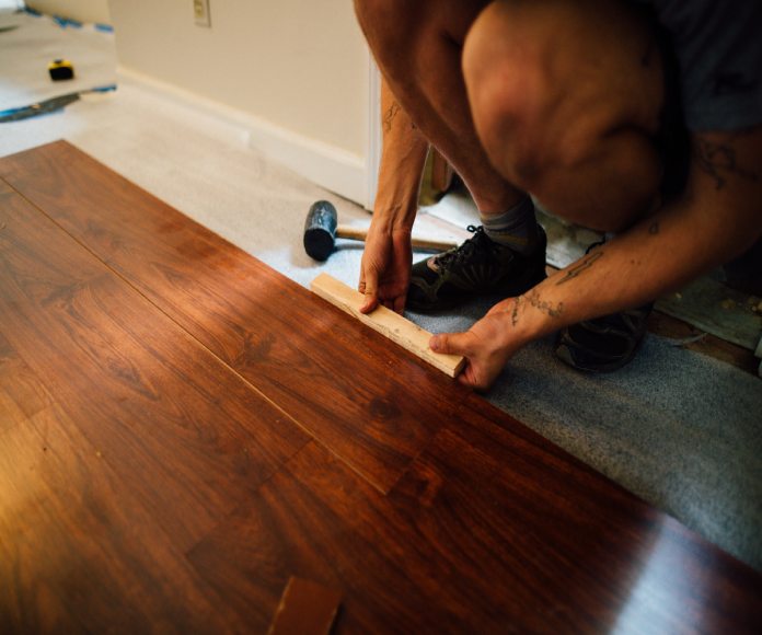 Hombre colocando suelo laminado