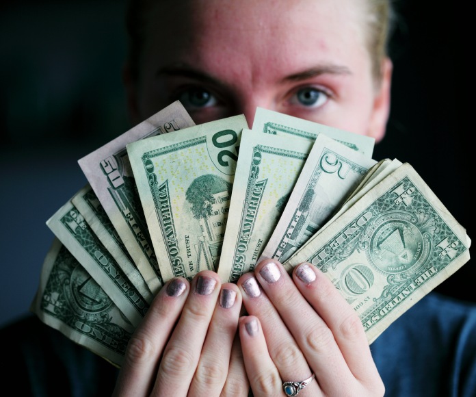 Mujer con varios billetes en sus manos.