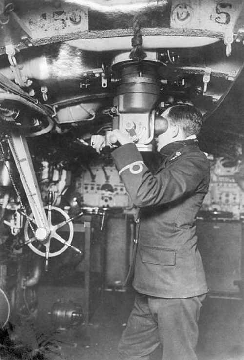 Oficial mirando a través del periscopio en submarino británico 