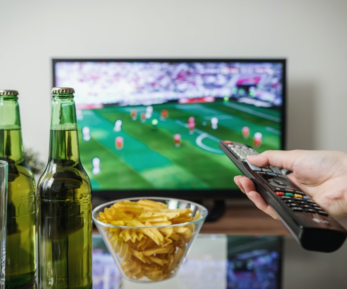 Persona viendo futbol en la televisión