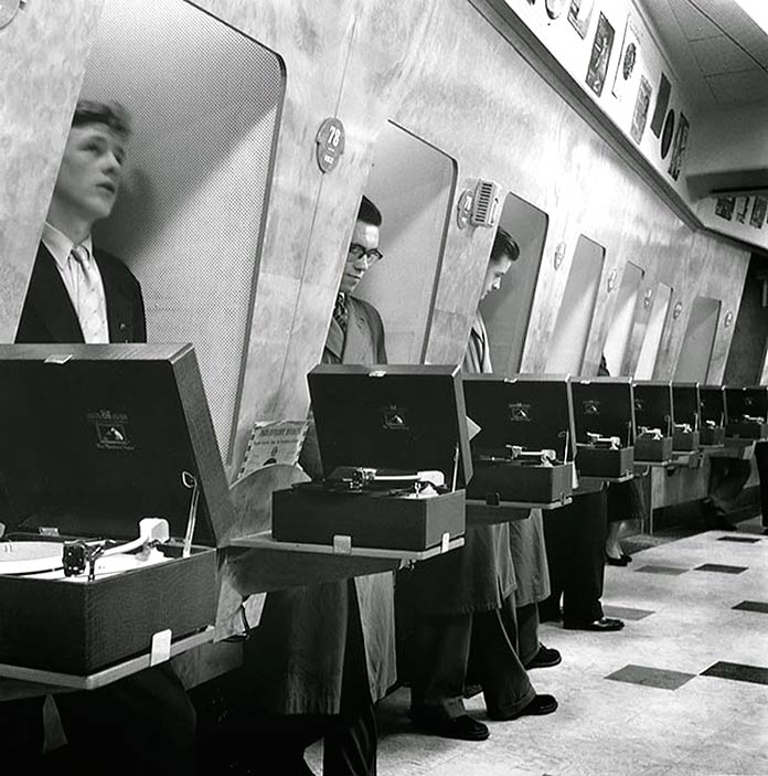 Clientes escuchando música en una tienda de discos. Londres, 1955