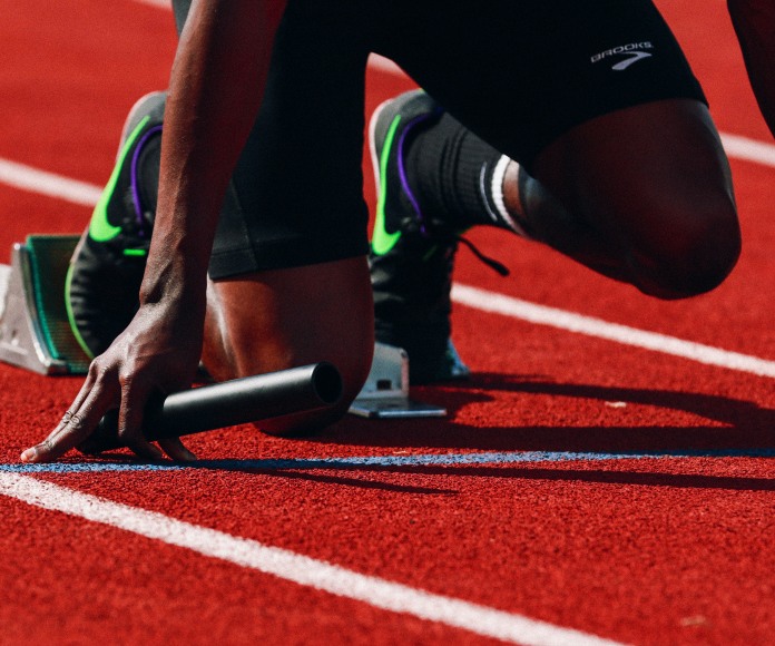 Atleta en posición de salida en una pista de atletismo.