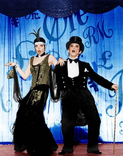 Un hombre y una mujer visten su atuendo burlesque en la comedia. 