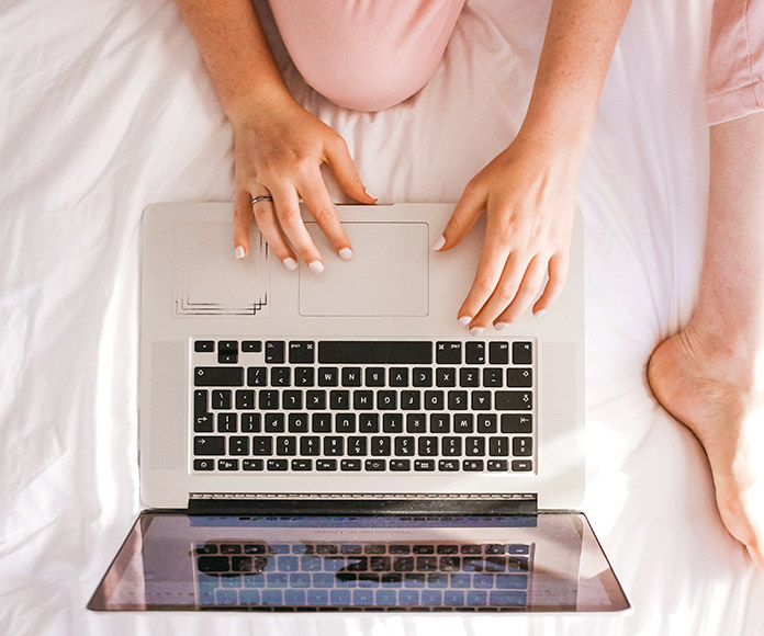 Mujer utilizando el portátil en la cama