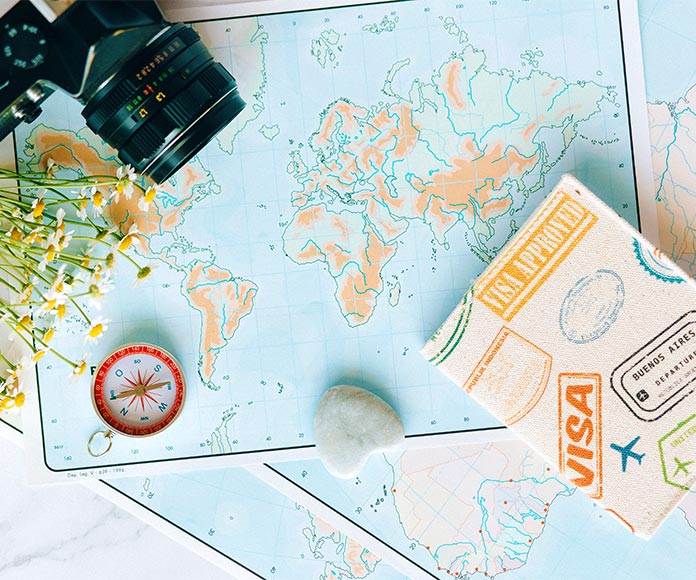 Concepto de viaje con mapas del mundo con pasaporte, brújula y cámara de fotos